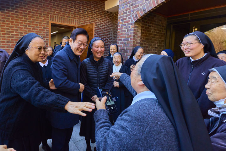 [서울=뉴시스] 최동준 기자 = 이재명 대통령이 25일 인천 계양구 노틀담 수녀원을 방문해 수녀들과 성탄 인사를 나누며 기념촬영을 하고 있다. (사진=대통령실 제공) 2025.12.25. photo@newsis.com *재판매 및 DB 금지