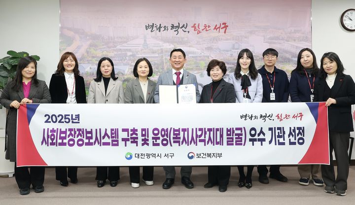 [대전=뉴시스] 조명휘 기자 = 서철모 대전 서구청장 등이 보건복지부 주관의 '사회보장정보시스템 구축 및 운영 평가' 복지 사각지대 발굴 부문에서 우수 지자체로 선정된 것을 기념해 사진촬영을 하고 있다. (사진= 서구청 제공) 2025.12.26. photo@newsis.com *재판매 및 DB 금지