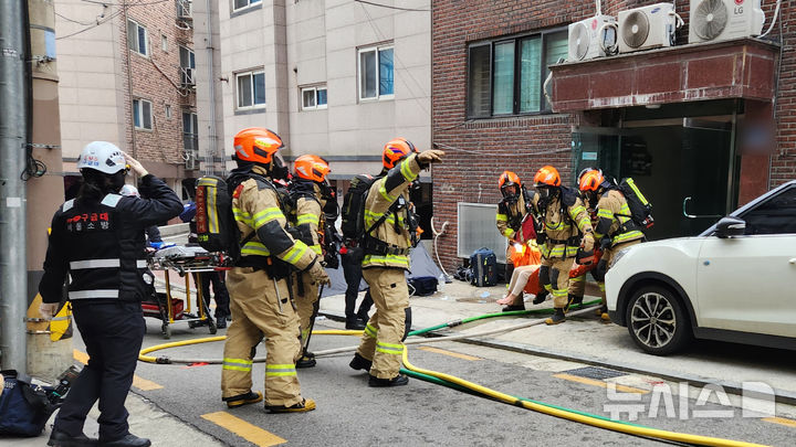 [서울=뉴시스] 서울 강동구 암사동의 한 다세대주택에서 화재가 발생해 소방대원들이 현장에서 부상자를 구조하고 있다. 이번 화재로 7명이 다쳤다. (사진=강동소방서 제공) 2025.12.27. photo@newsis.com 