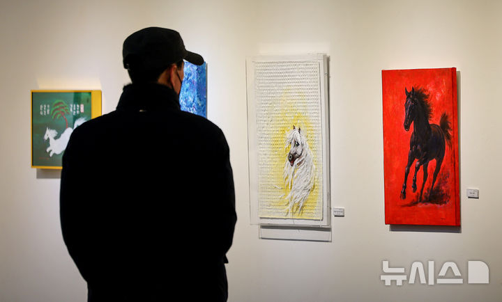 [대구=뉴시스] 이무열 기자 = 28일 대구 동구 아양아트센터 아양갤러리에서 열린 ‘2026 병오년(丙午年) 새해맞이 말(馬) 그림전’에서 관람객이 붉은 말을 주제로 한 작품을 감상하고 있다. 2025.12.28. lmy@newsis.com