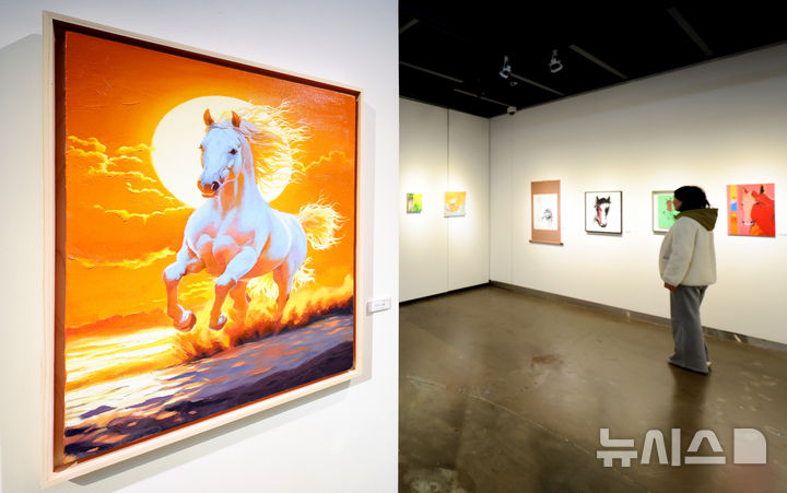 [대구=뉴시스] 이무열 기자 = 28일 대구 동구 아양아트센터 아양갤러리에서 열린 ‘2026 병오년(丙午年) 새해맞이 말(馬) 그림전’에서 관람객이 붉은 말을 주제로 한 작품을 감상하고 있다. 2025.12.28. lmy@newsis.com