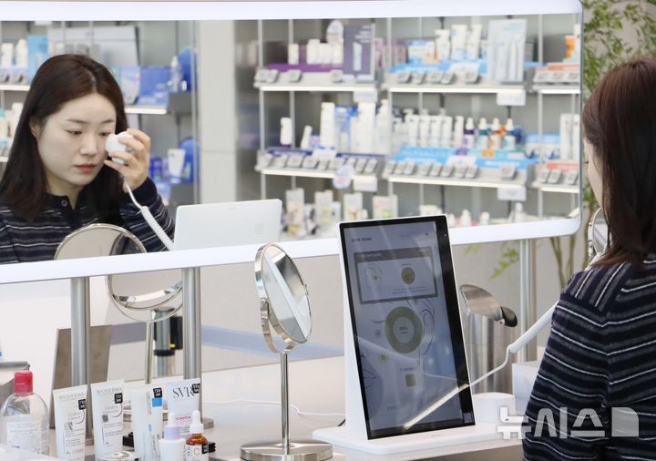 [서울=뉴시스] 한 고객이 서울 강남구 CJ올리브영 압구정로데오점에서 스킨스캔 서비스를 이용하고 있다. 올리브영은 이달 중순 체험형 뷰티케어 서비스 '스킨스캔'의 누적 이용 건수가 100만건을 돌파했다고 29일 밝혔다. (사진=CJ올리브영 제공) 2025.12.29. photo@newsis.com