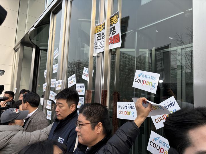 [서울=뉴시스] 권민지 수습기자 =전국민주노동조합총연맹(민주노총)은 29일 오전 서울 송파구 쿠팡 본사 앞에서 ' 반노동 반사회 범죄기업 쿠팡 규탄 노동자 시민 공동행동'을 개최한 뒤 쿠팡 본사 출입문에 스티커를 붙이는 모습.2025.12.29. ming@newsis.com *재판매 및 DB 금지 *재판매 및 DB 금지