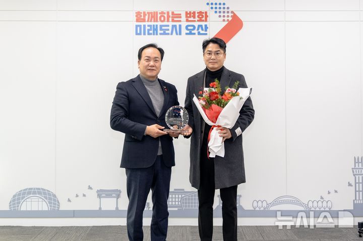 [오산=뉴시스] 이권재 오산시장이(사진 왼쪽)이 한국공인중개사협회 오산시지회 김진기 회장을 1일명예시장으로 위촉한 뒤 기념사진을 찍고 있다.(사진=오산시 제공)2025.12.29.photo@newsis.com 