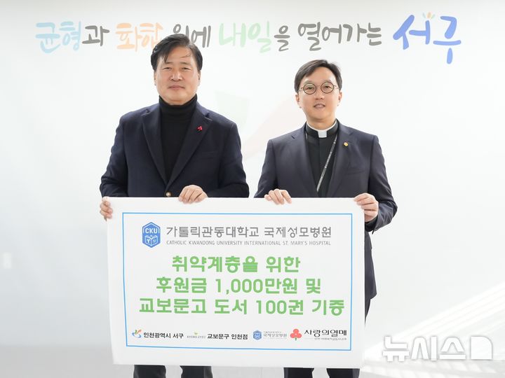 [인천=뉴시스] 인천 서구청에서 열린 후원금 및 기증도서 전달식에서 강범석 서구청장(왼쪽)과 국제성모병원장 고동현 신부가 기념 촬영하고 있다. (사진=국제성모병원 제공) 2025.12.29. photo@newsis.com