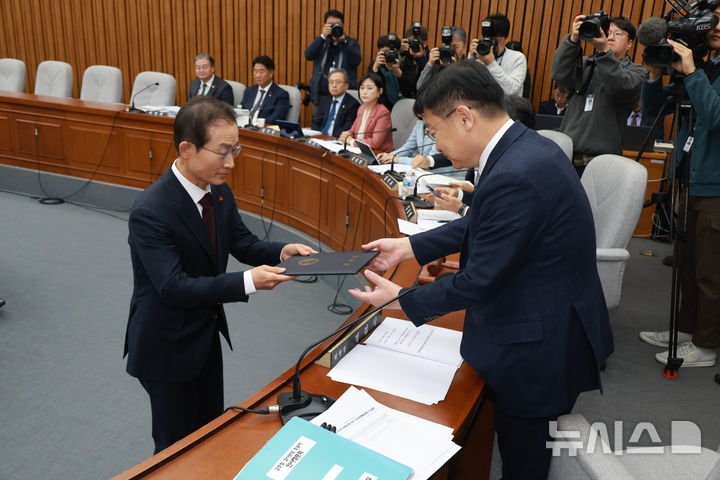 [서울=뉴시스] 고승민 기자 = 김호철 감사원장 후보자가 29일 서울 여의도 국회에서 열린 인사청문회에서 선서 후 선서문을 정점식 인사청문특위 위원장에게 전달하고 있다. 2025.12.29. kkssmm99@newsis.com