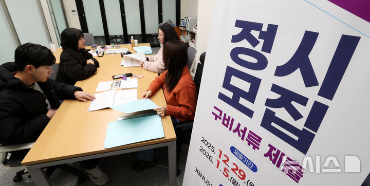 [전주=뉴시스] 김얼 기자 = 전북대학교 2026학년도 정시모집 원서 제출일인 29일 전북 전주시 전북대학교 JBNU인터내셔널센터 2층 접수처에서 관계자들이 관련 서류를 받고 있다. 2025.12.29. pmkeul@newsis.com