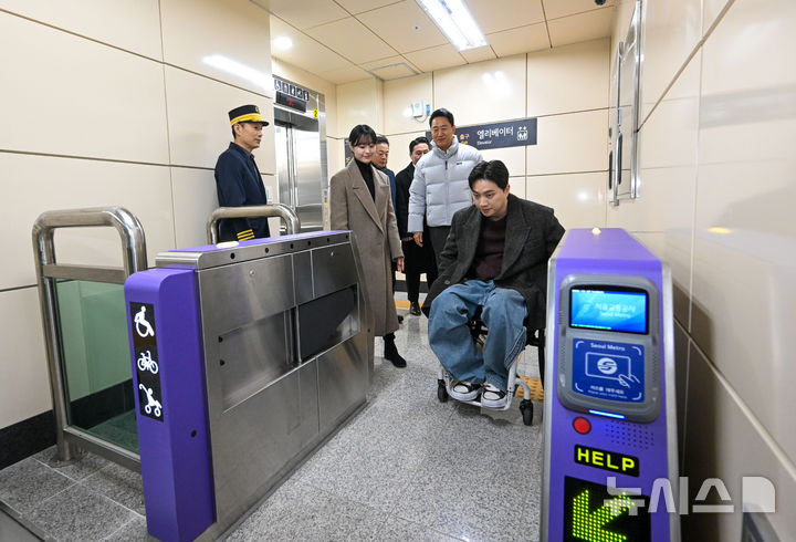 [서울=뉴시스] 박주성 기자 = 오세훈 서울시장이 29일 서울 강서구 까치산역에서 열린 전역사 1역사 1동선 확보 기념행사에서 교통약자 대표들과 함께 엘리베이터에서 내린 후 이동하고 있다. (공동취재).2025.12.29. photo@newsis.com