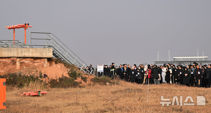 [무안=뉴시스] 이영주 기자 = 제주항공 여객기 참사 1주기인 29일 오후 전남 무안국제공항 활주로에서 참사 유가족들이 모여 여객기가 충돌한 콘크리트 둔덕(로컬라이저)의 잔해를 바라보고 있다. 2025.12.29. leeyj2578@newsis.com