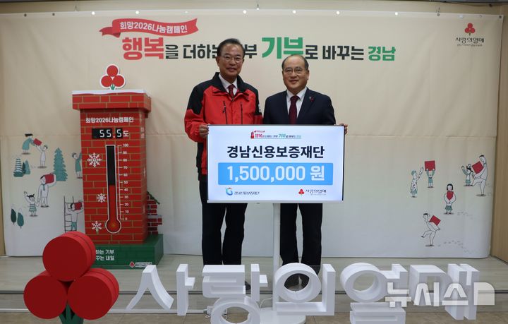 [창원=뉴시스]30일 경남신용보증재단 이효근(오른쪽) 이사장이 경남사회복지공동모금회 강기철 회장에게 이웃돕기 성금 150만원 기탁증서를 전달하고 있다. (사진=경남공동모금회 제공) 2025.12.30. photo@newsis.com