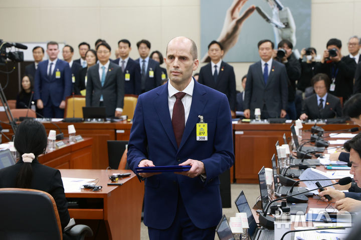 [서울=뉴시스] 고승민 기자 = 해롤드 로저스 쿠팡 대표이사 등 참석 증인들이 30일 서울 여의도 국회에서 열린 쿠팡 침해사고 및 개인정보 유출, 불공정 거래, 노동환경 실태 파악과 재발방지 대책 마련을 위한 청문회에서 선서를 마친 뒤 선서문을 전달하기 위해 최민희 위원장에게 향하고 있다. 2025.12.30. kkssmm99@newsis.com