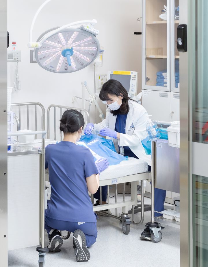 [수원=뉴시스] 이지숙 소아전문응급의료센터장이 센터 내 소생·처치실에서 환아를 진료하고 있다. 센터는 1인실 중심의 격리 공간 구조로 감염 차단과 진료 만족도를 동시에 높였다는 평가를 받고 있다. (사진=아주대병원 제공) 2026.01.01. photo@newsis.com *재판매 및 DB 금지