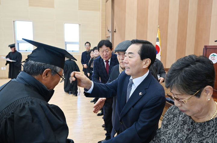 [창녕=뉴시스] 성낙인 군수가 졸업생의 학사모 수술 매무새를 가다듬어 주고 있다. (사진= 창녕군 제공) 2025.12.31. photo@newsis.com *재판매 및 DB 금지