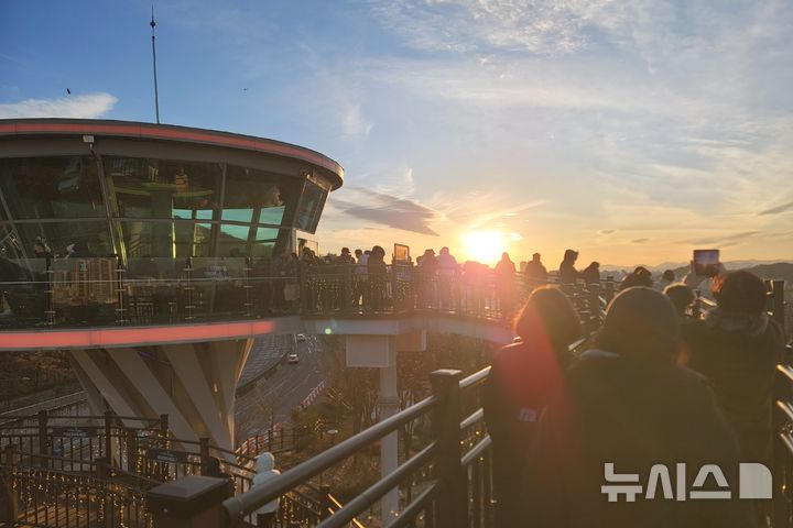 [대구=뉴시스] 이상제 기자 = 31일 대구 남구 앞산빨래터공원에 있는 해넘이전망대에서 시민들이 2025년 마지막 일몰을 촬영하고 있다. 2025.12.31. king@newsis.com 