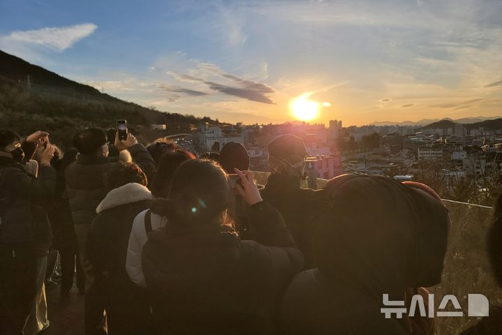 [대구=뉴시스] 이상제 기자 = 31일 대구 남구 앞산빨래터공원에 있는 해넘이전망대에서 시민들이 2025년 마지막 일몰을 촬영하고 있다. 2025.12.31. king@newsis.com 