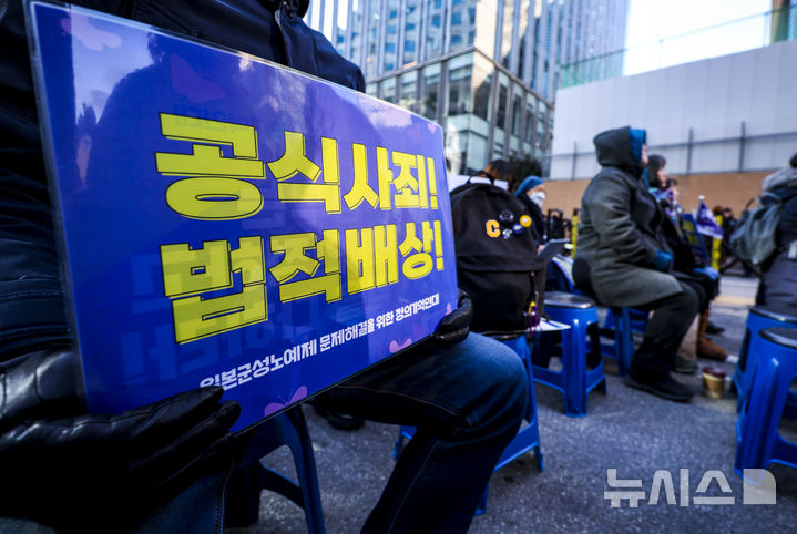 [서울=뉴시스] 정병혁 기자 = 31일 서울 종로구 옛 일본대사관 앞에서 열린 1733차 일본군성노예제 문제해결을 위한 수요시위에서 참석자들이 피켓을 들고 있다. 2025.12.31. jhope@newsis.com