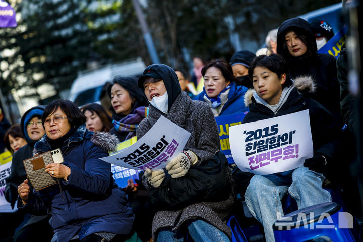 [서울=뉴시스] 정병혁 기자 = 31일 서울 종로구 옛 일본대사관 앞에서 열린 1733차 일본군성노예제 문제해결을 위한 수요시위에서 참석자들이 피켓을 들고 있다. 2025.12.31. jhope@newsis.com