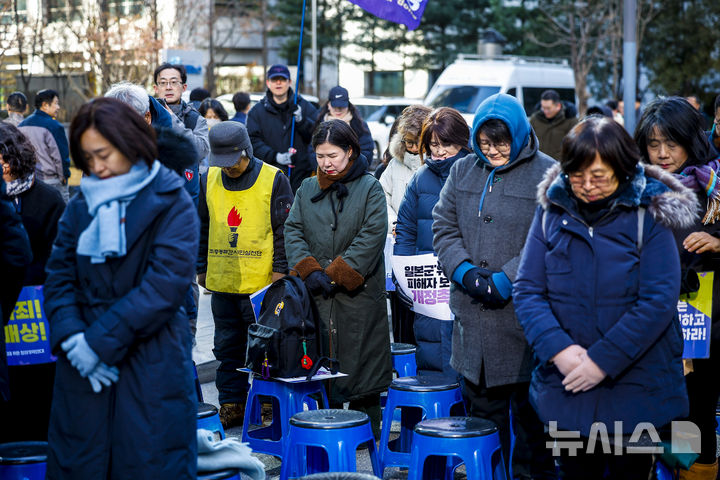 [서울=뉴시스] 정병혁 기자 = 31일 서울 종로구 옛 일본대사관 앞에서 열린 1733차 일본군성노예제 문제해결을 위한 수요시위에서 참가자들이 돌아가신 할머니들을 추모하며 묵념하고 있다. 2025.12.31. jhope@newsis.com