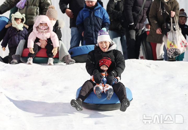 [서울=뉴시스] 김진아 기자 = 31일 서울 광진구 뚝섬한강공원 눈썰매장을 찾은 외국인 관광객들이 눈썰매를 타고 있다.&nbsp; 겨울철을 맞아 이날 개장한 뚝섬, 잠원, 여의도 한강공원 눈썰매장은 내년 2월18일까지 운영된다. 2025.12.31. bluesoda@newsis.com