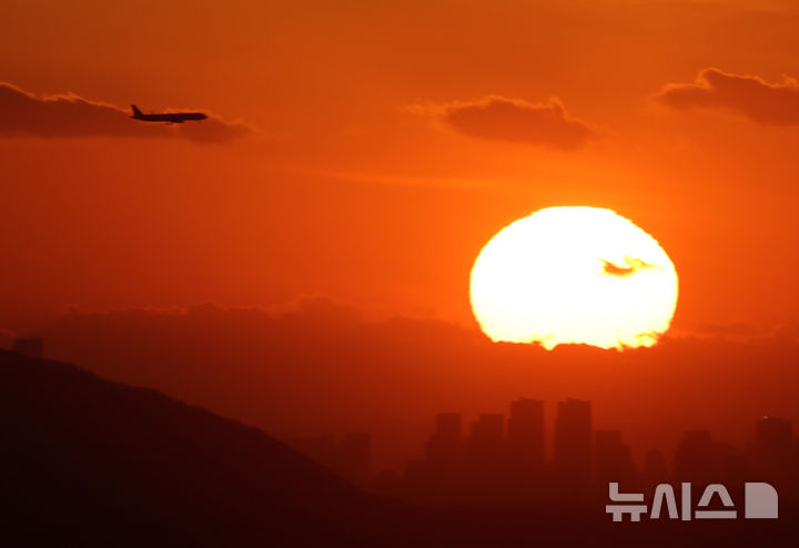 [서울=뉴시스] 배훈식 기자 = 2025년 을사년(乙巳年)의 마지막 날인 31일 오후 서울 용산구 서울N타워에서 바라본 마지막 해넘이를 뒤로하고 비행기가 날고 있다. 2025.12.31. dahora83@newsis.com