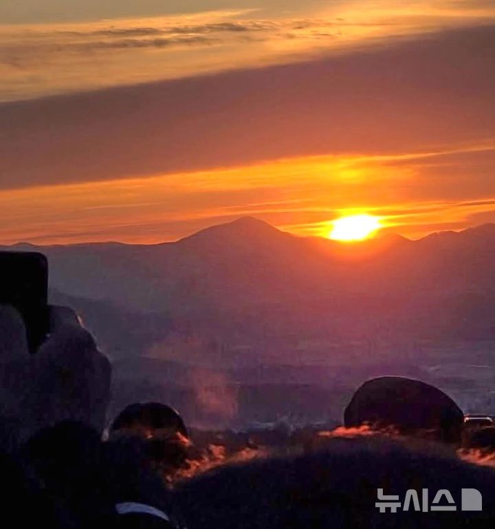 [보은=뉴시스] 연종영 기자 = 1일 오전 충북 보은군 보은읍 삼년산성에서 해맞이 나온 주민들이 휴대전화에 새해 첫 일출을 담고 있다. 충북 중남부 지역에선 동그랗고 밝고 붉은 해를 관측할 순 없었다. 민족통일보은군협의회는 삼년산성 동쪽 성벽에서 해맞이 행사를 주관했다. 2026.01.01. jyy@newsis.com&nbsp; *재판매 및 DB 금지
