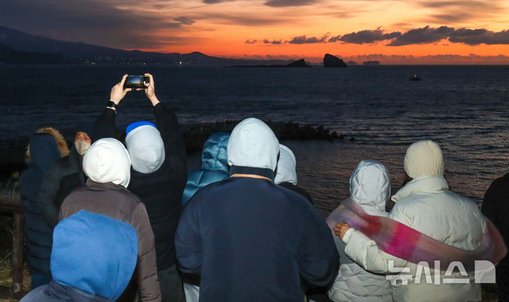 [서귀포=뉴시스] 우장호 기자 = 병오년(丙午年) 새해 첫날인 1일 오전 제주 서귀포시 대정읍 송악산 둘레길을 찾은 해맞이객들이 구름 뒤로 떠오르는 일출을 맞이하고 있다. 2026.01.01. woo1223@newsis.com