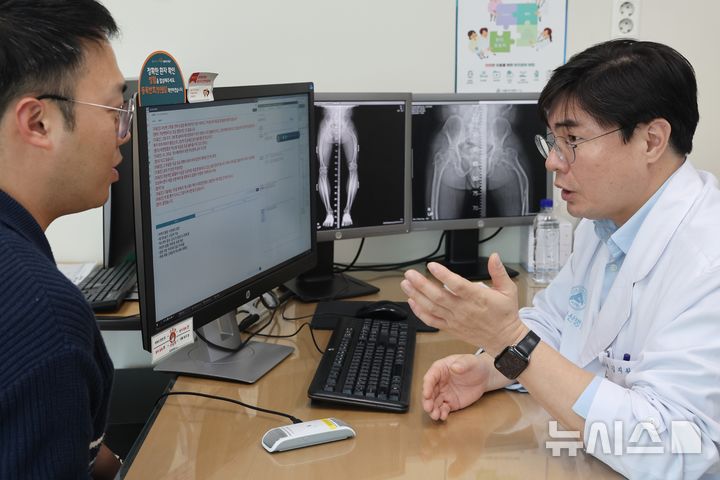 [서울=뉴시스] 김지완 서울아산병원 정형외과 교수가 인공지능(AI) 진료 음성인식 시스템을 활용해 환자를 진료하고 있다. 전용 마이크를 통해 입력된 의료진과 환자의 음성 데이터가 실시간 텍스트로 기록·요약되고, 주요 정보가 전자의무기록에 자동으로 저장된다. (사진= 서울아산병원 제공)