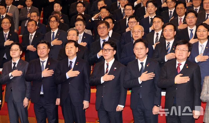 [세종=뉴시스] 강종민 기자 = 김민석 국무총리와 각 부처 장관들이 2일 세종시 정부세종청사 대강당에서 열린 2026 정부 시무식에서 국기에 경례하고 있다. 2026.01.02. ppkjm@newsis.com