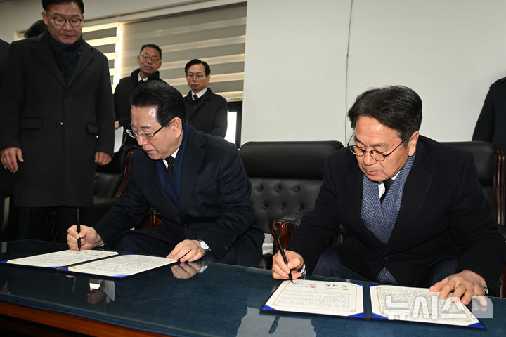 [광주=뉴시스] 이영주 기자 = 강기정(오른쪽) 광주시장과 김영록 전남도지사가 2일 오전 광주 국립5·18민주묘지에서 시도통합 선언문에 서명하고 있다. 2026.01.02. leeyj2578@newsis.com