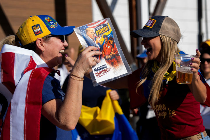[케이티=AP/뉴시스] 3일(현지 시간) 도널드 트럼프 미국 대통령이 니콜라스 마두로 베네수엘라 대통령 부부를 체포해 국외로 이송했다고 발표한 뒤 텍사스주 케이티에서 두 여성이 관련 전단을 들고 춤추며 환호하고 있다. 2026.01.04.