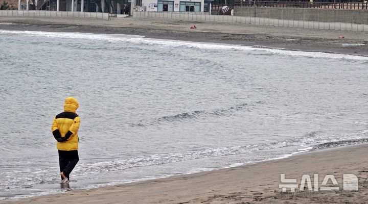 [제주=뉴시스] 오영재 기자 = 흐린 날씨를 보인 4일 오후 제주시 이호테우해변에서 시민이 맨발로 걷는 활동인 '어싱'을 하고 있다. 2026.01.04. oyj4343@newsis.com