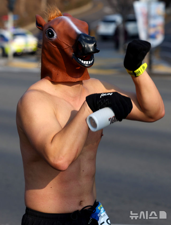 [대구=뉴시스] 이무열 기자 = 4일 대구 달서구 두류공원 2.28 자유광장에서 열린 2026 전국 새해 알몸마라톤대회에서 한 참가자가 말의 탈을 쓰고 힘차게 달리고 있다. 2026.01.04. lmy@newsis.com