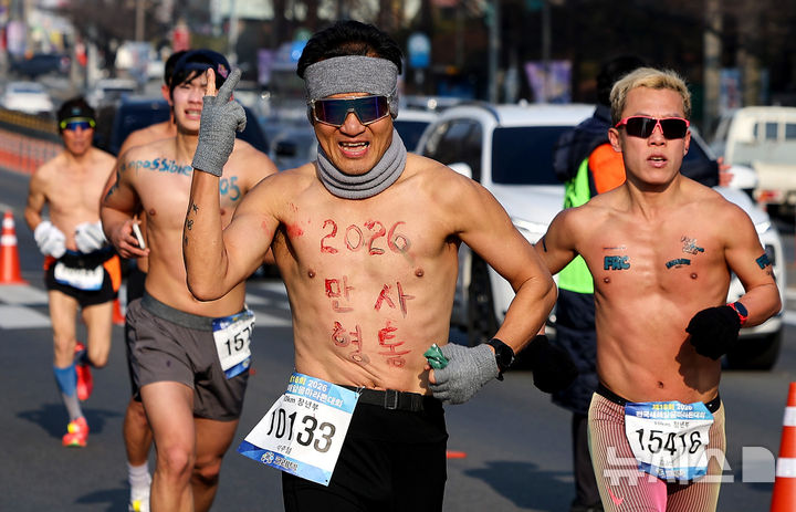 [대구=뉴시스] 이무열 기자 = 4일 대구 달서구 두류공원 2·28 자유광장에서 열린 전국 새해 알몸마라톤대회에서 몸에 새해 소망을 적은 참가자들이 힘차게 달리고 있다. 2026.01.04. lmy@newsis.com