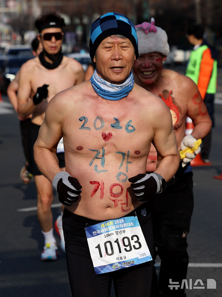 [대구=뉴시스] 이무열 기자 = 4일 대구 달서구 두류공원 2.28 자유광장에서 열린 2026 전국 새해 알몸마라톤대회에서 몸에 새해 소망을 적은 참가자들이 힘차게 달리고 있다. 2026.01.04. lmy@newsis.com