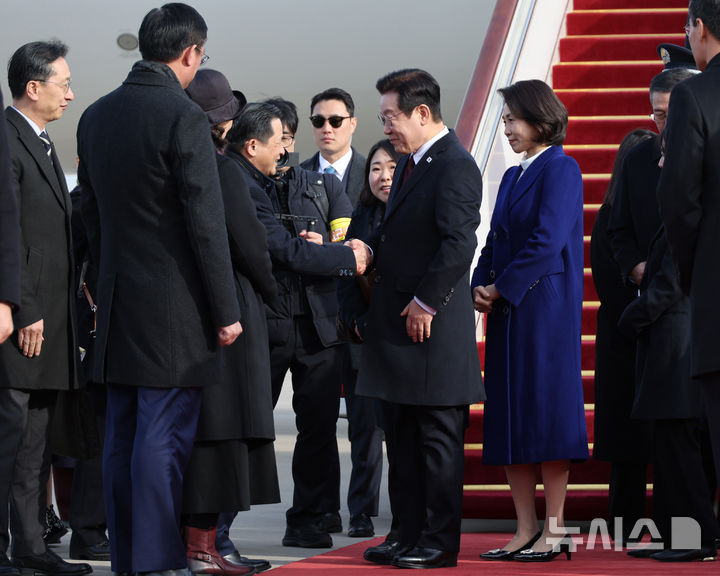 [베이징=뉴시스] 최동준 기자 = 중국을 국빈 방문한 이재명 대통령과 김혜경 여사가 4일(현지 시간) 베이징 서우두 국제공항에 도착해 환영 인사들과 인사하고 있다. 2026.01.04. photocdj@newsis.com