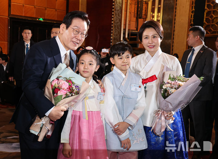 [베이징=뉴시스] 최동준 기자 = 중국을 국빈 방문 중인 이재명 대통령과 김혜경 여사가 4일(현지 시간) 베이징의 한 호텔에서 열린 재중 한국인 간담회에서 화동들과 기념촬영을 하고 있다. 2026.01.04. photocdj@newsis.com