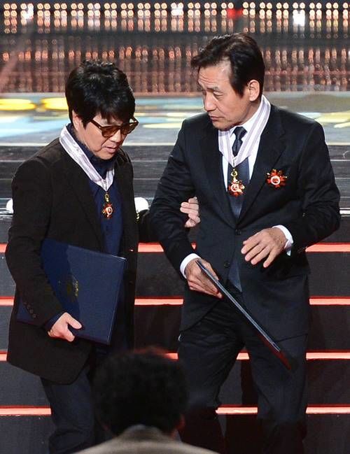 [서울=뉴시스] 중학교 동창인 가왕 조용필과 국민배우 안성기가 2013년 11월18일 서울 송파구 방이동 올림픽공원 올림픽홀에서 열린 '2013 대한민국 대중문화예술상' 시상식에서 함께 은관 문화훈장을 받은 뒤 이야기를 나누며 자리로 돌아가고 있다. (사진 = 뉴시스 DB) 2026.01.05. photo@newsis. *재판매 및 DB 금지