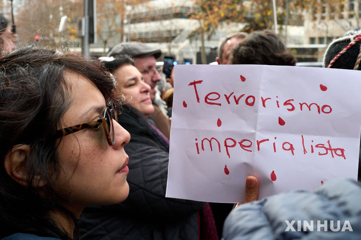 [마드리드( 스페인)=신화/뉴시스] 마드리드의 미 대사관 앞에서 4일 베네수엘라를 지지하는 시위대가 집회에서 "테러리즘 반대, 제국주의 반대"를 쓴 종이를 든 채 미국의 무력침공과 국제법 위반에 항의하고 있다. 미국의 무력침공과 마두로 대통령 강제납치는 세계적으로 강력한 반대와 비난을 받고 있다고 이들은 주장했다. 2026. 01.05. 