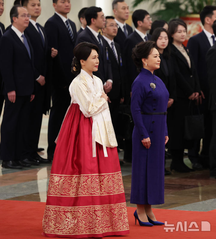 [베이징=뉴시스] 최동준 기자 = 이재명 대통령과 함께 중국을 국빈 방문한 김혜경 여사가 5일(현지 시간) 베이징 인민대회당에서 열린 공식환영식에서 국기에 경례하고 있다. 2026.01.05. photocdj@newsis.com