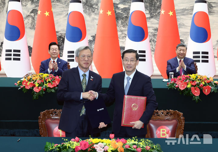 [베이징=뉴시스] 최동준 기자 = 유홍준(왼쪽) 국립중앙박물관장과 라오취안 중국 국가문물국 국장이 5일(현지 시간) 중국 베이징 인민대회당에서 이재명 대통령과 시진핑 국가주석이 임석한 가운데 중국 청대 석사자상 한 쌍 기증 증서를 작성한 뒤 기념촬영을 하고 있다. 2026.01.05. photocdj@newsis.com