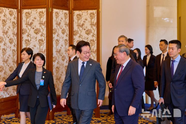 [베이징=뉴시스] 최동준 기자 = 중국을 국빈 방문 중인 이재명 대통령이 6일(현지 시간) 베이징 조어대에서 리창 국무원 총리와 오찬을 위해 이동하며 대화하고 있다. (공동취재) 2026.01.06. photocdj@newsis.com