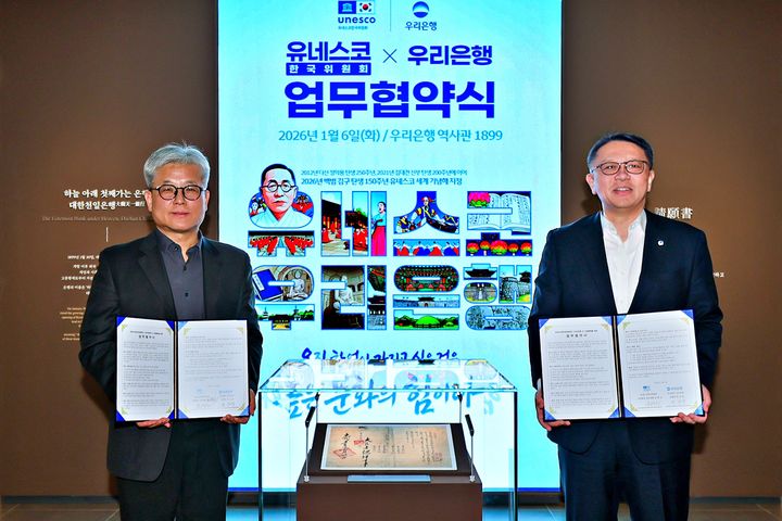 6일 우리은행 역사관 '우리1899'에서 열린 협약식에서 우리은행 정진완 은행장(오른쪽)과 유네스코한국위원회 윤병순 사무총장 직무대행이 대한천일은행 창립청원서 앞에서 기념촬영을 하고 있다. (사진=우리은행 제공) *재판매 및 DB 금지