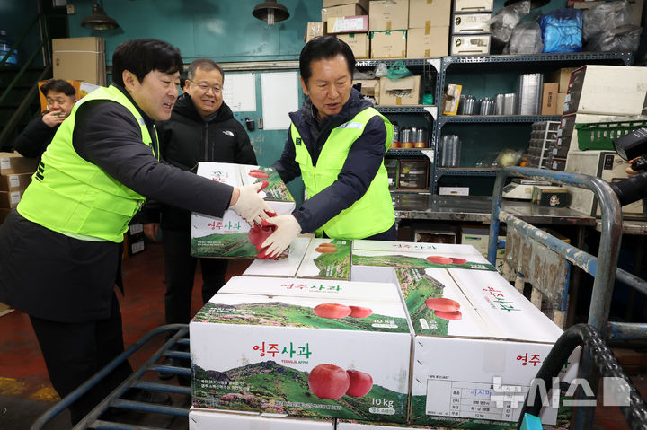[서울=뉴시스] 조성우 기자 = 정청래(오른쪽) 더불어민주당 대표와 황명선 최고위원이 7일 오전 서울 송파구 가락동 농수산물 종합도매시장 중앙청과에서 경매를 마친 사과 상자를 옮기고 있다. 2026.01.07. xconfind@newsis.com