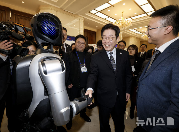 [상하이=뉴시스] 최동준 기자 = 중국을 국빈 방문 중인 이재명 대통령이 7일(현지 시간) 상하이 상해국제회의중심에서 열린 한-중 벤처스타트업 서밋을 방문해 중국 기업 엣지봇의 휴머노이드 로봇과 악수를 하고 있다. 2026.01.07. photocdj@newsis.com