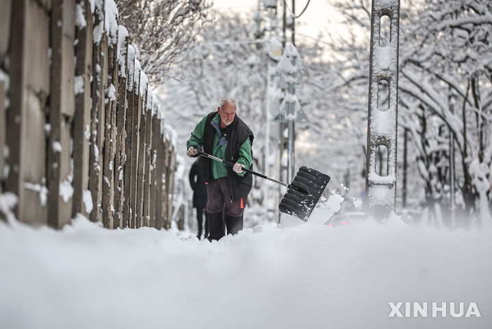 [부다페스트=신화/뉴시스] 7일(현지 시간) 헝가리 부다페스트의 한 거리에서 남성이 눈을 치우고 있다. 2026.01.08.