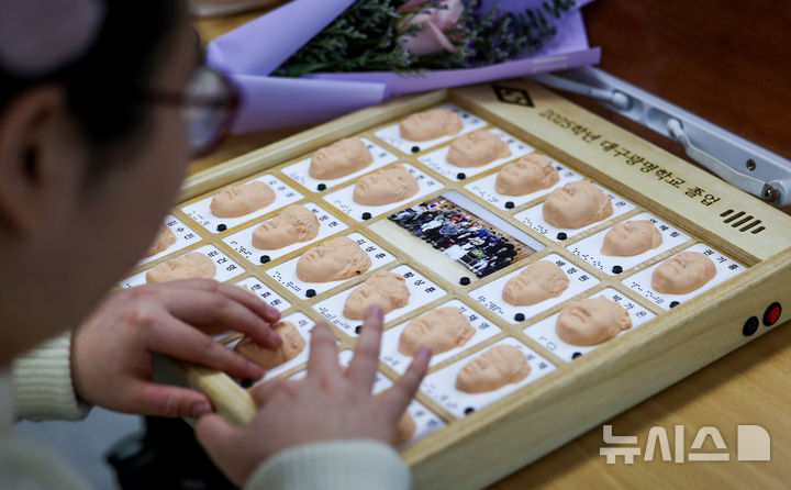 [대구=뉴시스] 이무열 기자 = 8일 대구 남구 시각장애 학생을 위한 교육기관인 대구광명학교에서 열린 2025학년도 졸업식에서 졸업생들이 3D 프린터로 제작된 졸업앨범 속 친구 얼굴을 손끝으로 만져보고 있다. 2026.01.08. lmy@newsis.com **기사 내용과 직접 관련 없습니다**