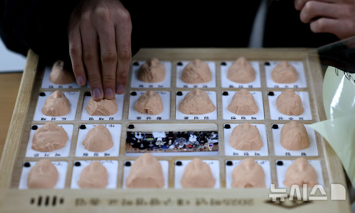 [대구=뉴시스] 이무열 기자 = 8일 대구 남구 시각장애 학생을 위한 교육기관인 대구광명학교에서 열린 2025학년도 졸업식에서 졸업생들이 3D 프린터로 제작된 졸업앨범 속 친구 얼굴을 손끝으로 만져보고 있다. 2026.01.08. lmy@newsis.com