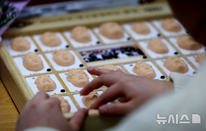 [대구=뉴시스] 이무열 기자 = 지난 1월 8일 대구 남구 시각장애 학생을 위한 교육기관인 대구광명학교에서 열린 2025학년도 졸업식에서 졸업생들이 3D 프린터로 제작된 졸업앨범 속 친구 얼굴을 손끝으로 만져보고 있는 모습. 2026.01.08. lmy@newsis.com