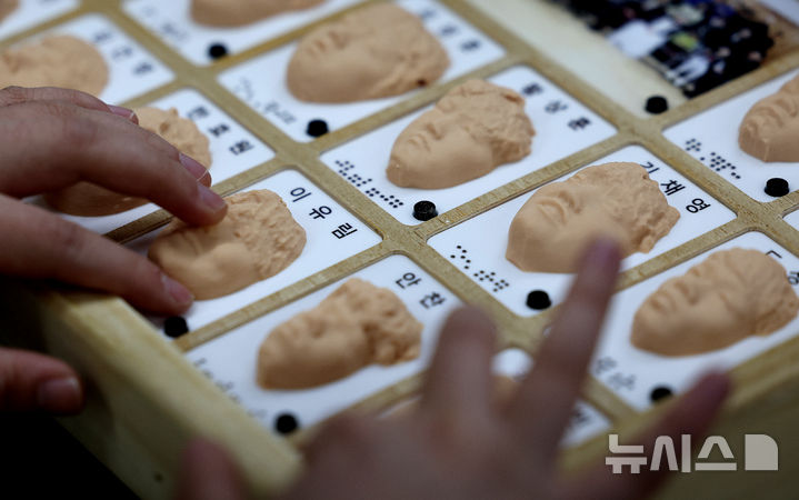 [대구=뉴시스] 이무열 기자 = 8일 대구 남구 시각장애 학생을 위한 교육기관인 대구광명학교에서 열린 2025학년도 졸업식에서 졸업생들이 3D 프린터로 제작된 졸업앨범 속 친구 얼굴을 손끝으로 만져보고 있다. 2026.01.08. lmy@newsis.com