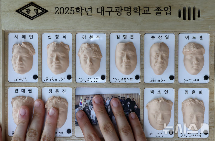 [대구=뉴시스] 이무열 기자 = 8일 대구 남구 시각장애 학생을 위한 교육기관인 대구광명학교에서 열린 2025학년도 졸업식에서 졸업생들이 3D 프린터로 제작된 졸업앨범 속 친구 얼굴을 손끝으로 만져보고 있다. 2026.01.08. lmy@newsis.com